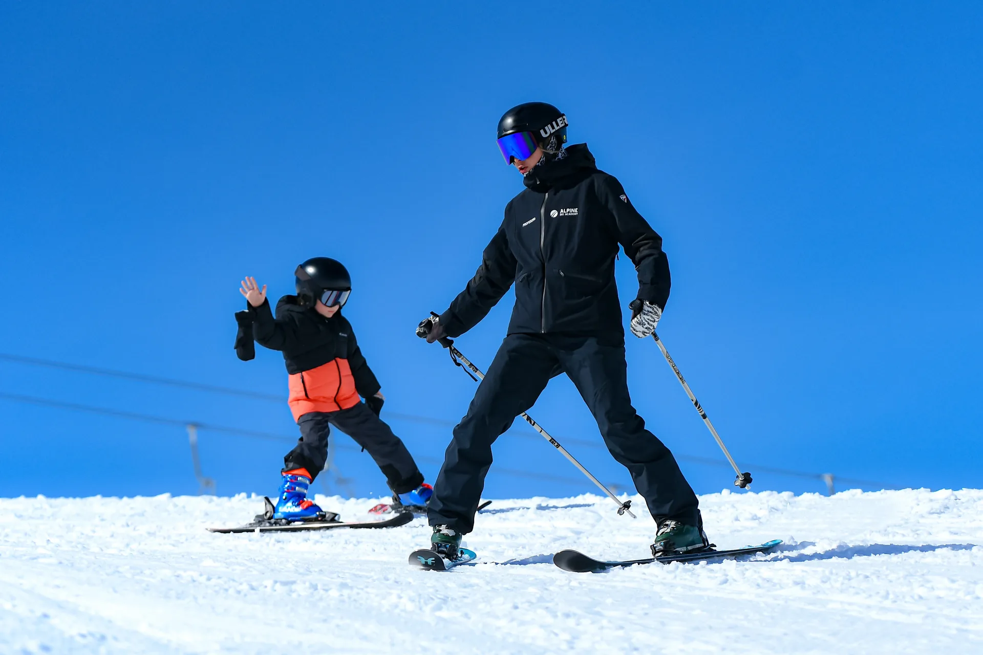 Moniteur d'Alpine Ski Academy enseignant le chasse-neige à un jeune débutant à Baqueira