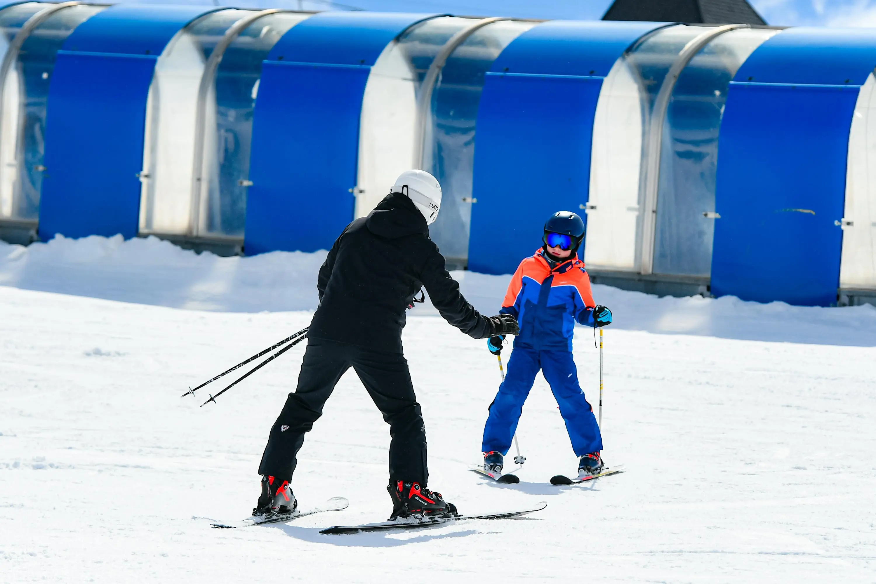 Instructor mostrando la posición base de esquí a un principiante en Baqueira