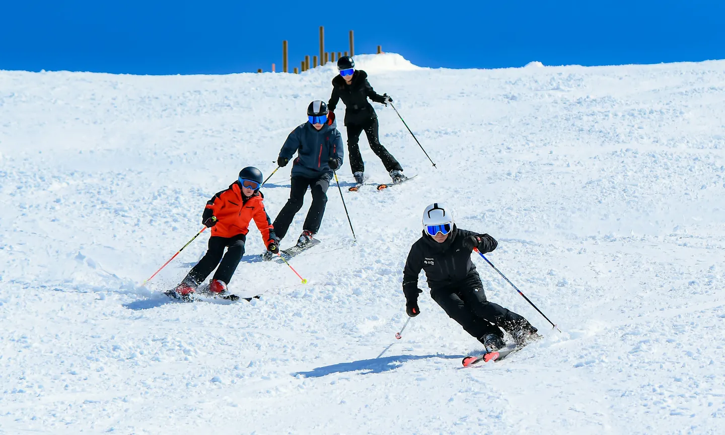 group of skiers coming down in single file behind their instructor on a Baqueira Beret slope — Alpine Ski Academy
