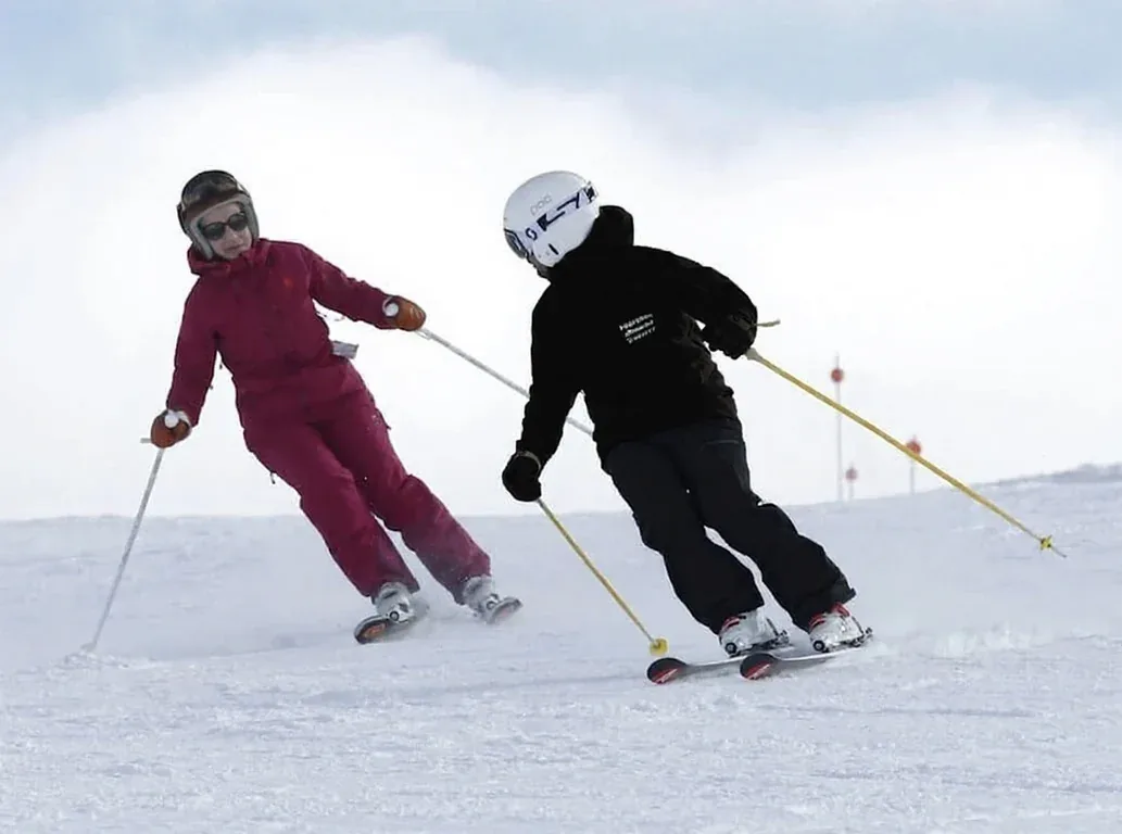 Moniteur et élève skiant en parallèle pendant un cours technique à Baqueira Beret — Alpine Ski Academy