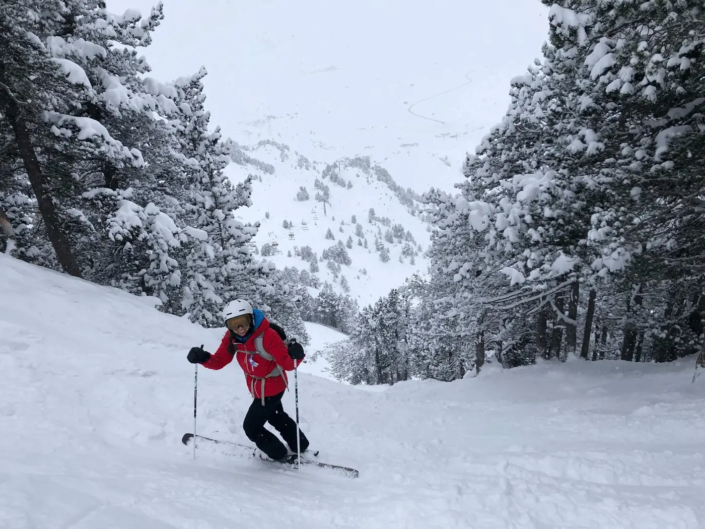 Skieuse de niveau avancé descendant un terrain technique boisé à Baqueira Beret — Alpine Ski Academy