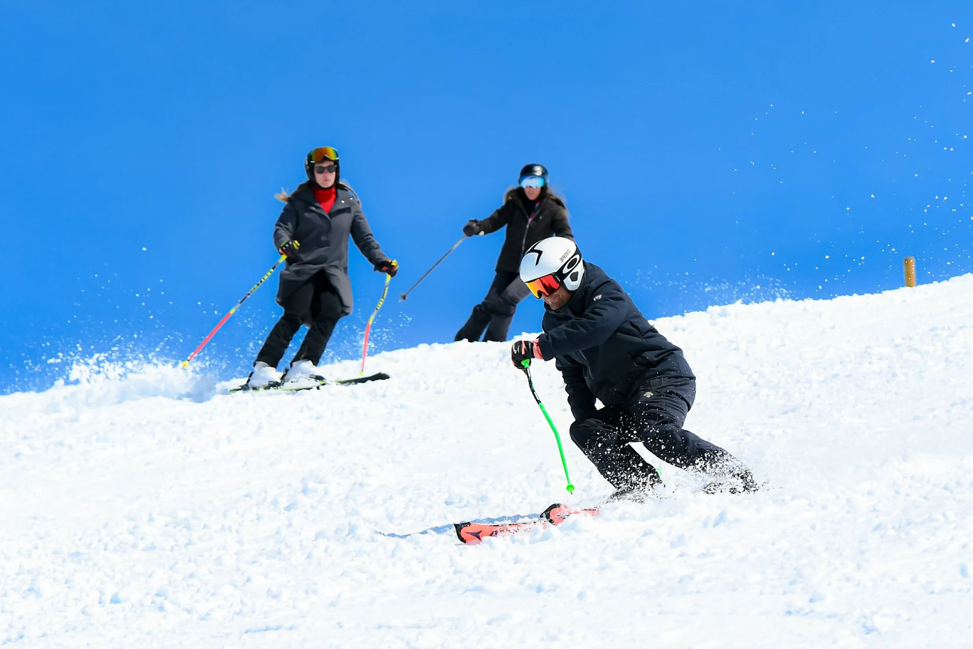 Instrutor de esqui a abrir uma curva cortada seguido de duas alunas de nível D-E em Baqueira Beret — Alpine Ski Academy