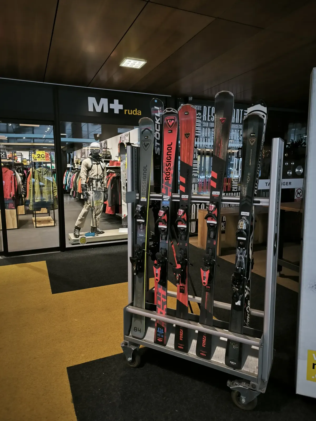 Fachada de tienda M Plus Ruda en Baqueira 1500 con esquiadores recogiendo material