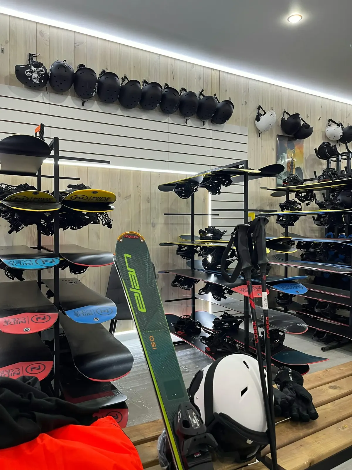 Familia con esquís y tablas de snowboard saliendo de tienda de alquiler en Baqueira